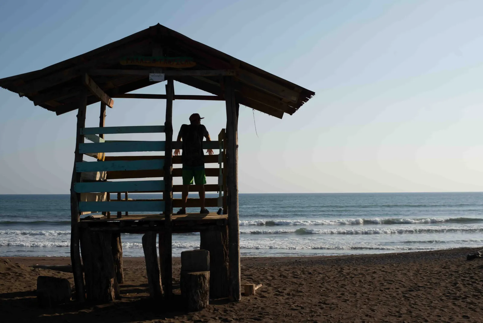 Two people walking the wide reflective sand at low tide on the Osa Peninsula